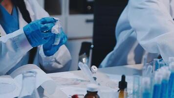 Two people in lab coats working on a project video