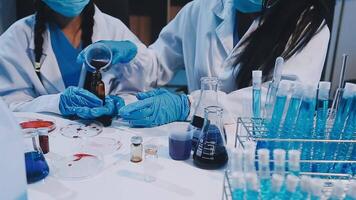 Two people in lab coats and masks working on a project video