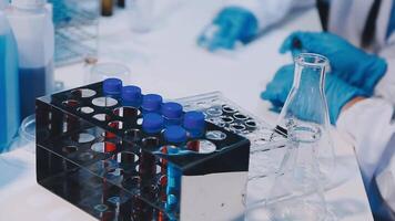 A person in a lab coat is working on a test tube video