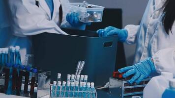 Two people in lab coats and gloves working on a container video