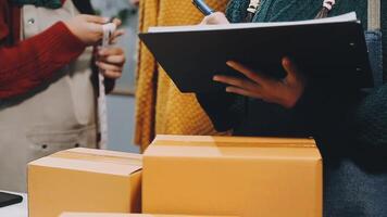 A woman is holding a clipboard and looking at a box video