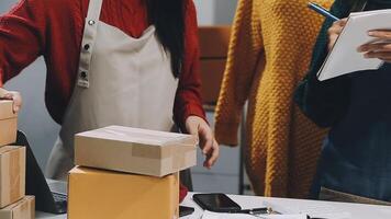 Two women are working on a computer and a box video