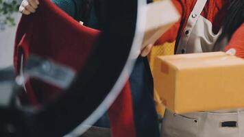 A woman is holding a box in front of a mirror video