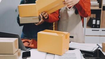 Two people are working on a desk with boxes video