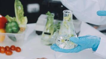 A person in a lab coat holding a glass with food in it video