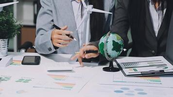 Business people working on a desk with a globe and other items video