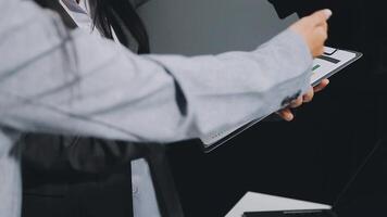 A woman in a business suit holding a tablet computer video