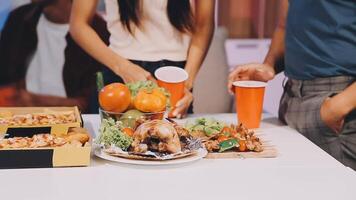 A group of people standing around a table with food video