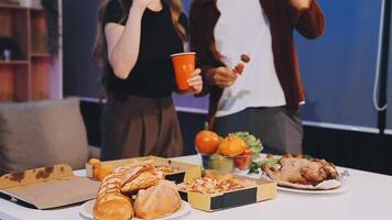 A man and woman standing in front of a table with food video