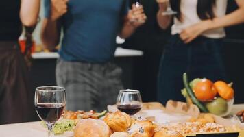 A group of people standing around a table with food and wine video