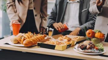 A group of people standing around a table with food video