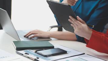 Two people sitting at a table with a laptop and papers video