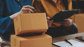 Two people are working on a laptop and a box video