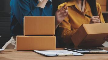 Two women are sitting at a table with boxes video