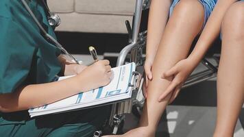 A doctor is writing on a clipboard while a patient sits in a wheelchair video