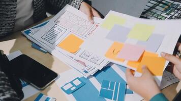 A group of people working on a project with paper and sticky notes video