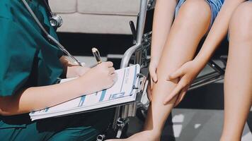 A doctor is writing on a clipboard while a woman sits in a wheelchair video