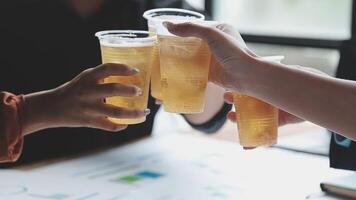 Three people toasting with drinks on a table video