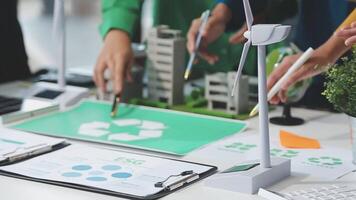 A group of people working on a project with a recycling symbol video
