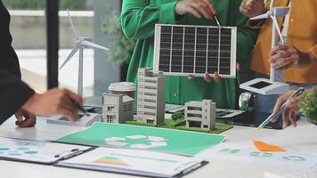 A group of people working on a project with a model of a solar panel video