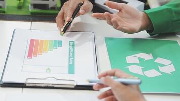 A man and woman are working on a document with a recycling symbol video