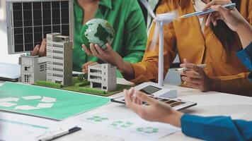 A group of people working on a project with a model of a recycling plant video