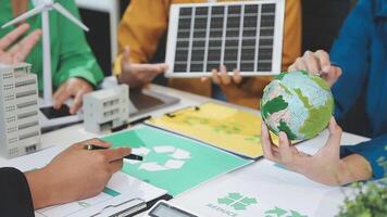 People working on a project with a green earth and a solar panel video