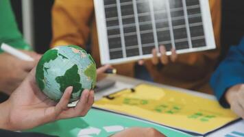 A group of people are holding a globe with a solar panel on it video