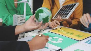 Business people working on a project with a green globe video