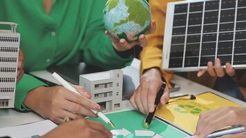 People working on a project with a green building and solar panels video