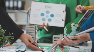 Business people working on a project with a green globe video