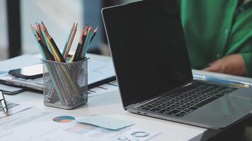 A laptop with a pen and pencils on a desk video