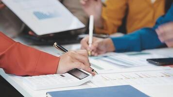 Business people working on a document with a calculator video