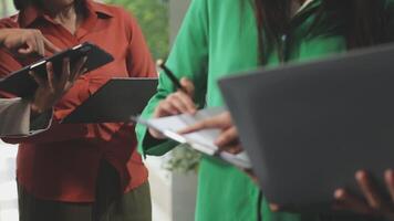 Trois gens permanent autour une table avec ordinateurs portables video