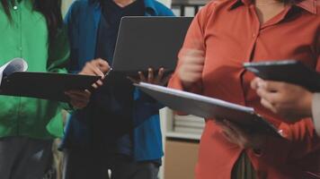 une groupe de gens permanent autour une table avec ordinateurs portables video