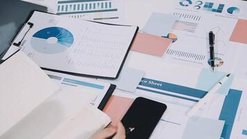 Businessman's hands on desk with papers and graphs video
