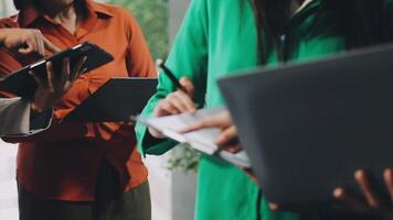 Trois gens permanent autour une table avec ordinateurs portables video