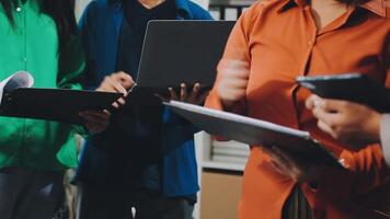 une groupe de gens permanent autour une table avec ordinateurs portables video