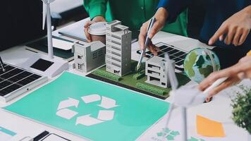 A group of people working on a table with a recycling symbol video