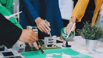People working on a paper model of a city video