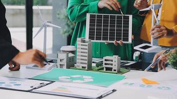 A group of people working on a project with a model of a solar panel video