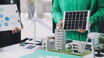 A man holding a paper with a solar panel and wind turbines video
