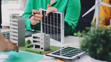 A group of people working on a model of a solar panel video
