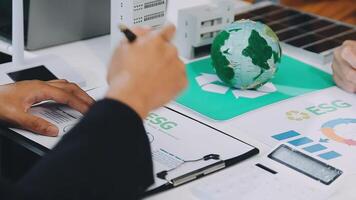 Business people working on a project with a green globe video