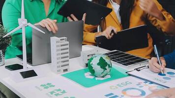 A group of people working on a laptop with a green building on it video