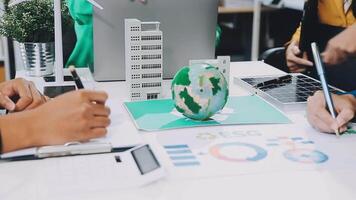 People working on a project at a table with a globe and other items video