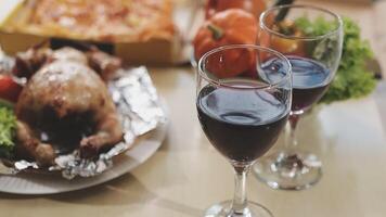 Two glasses of red wine with a turkey on the table video