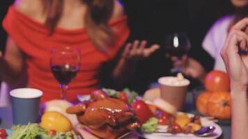 A group of people sitting at a table with food and drinks video