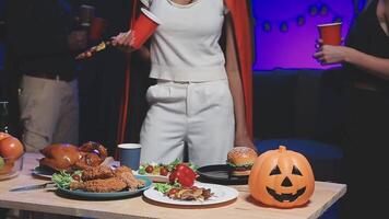 A woman in a halloween costume stands next to a table with food video