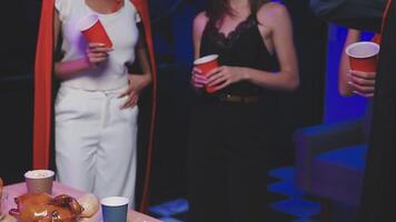 A group of people standing around a table with drinks video